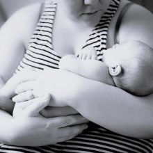 Junge Mutter hält Baby im Arm